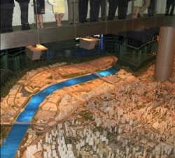 Sus Majestades los Reyes contemplan el desarrollo de Shanghai sobre una enorme maqueta de la ciudad del año 2020, junto al alcalde de la Shanghai, Han