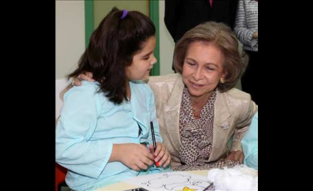 Su Majestad conversa con una niña durante su visita