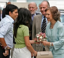 Los Reyes reciben un ramo de flores de manos de dos alumnos a su llegada al colegio