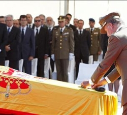 Don Juan Carlos impone la Medalla al Mérito Militar con distintivo rojo, concedida a título póstumo, sobre los féretros con los restos mortales de los