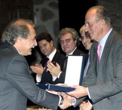Don Juan Carlos hace entrega del galardón al  presidente de Caja Castilla-La Mancha, Juan Pedro Hernández Moltó