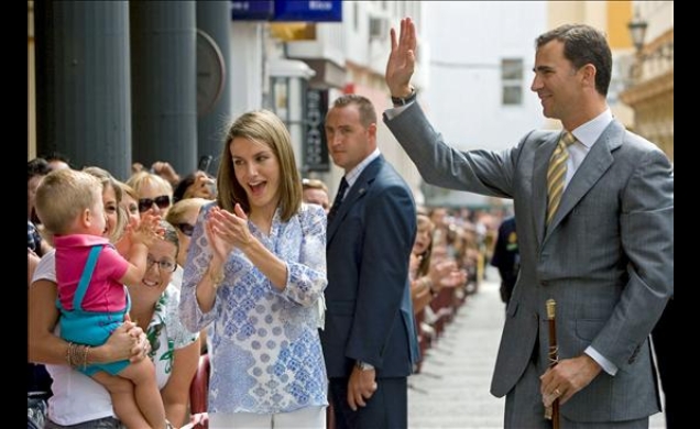 Sus Altezas Reales los Príncipes de Asturias saludan al público que se congregaba a su llegada a la calle Real