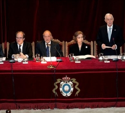 Sus Majestades, en la mesa presidencial, durante la intervención del director de la RAE
