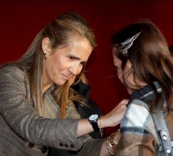 Doña Elena, impone una insignia de la Fiesta de la Banderita