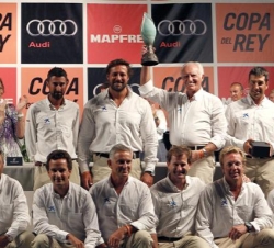 La tripulación del Bribón, con su armador José Cusí, posa con el trofeo que les acredita como ganadores de la trigésima Copa del Rey de vela