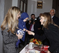 Su Alteza coversa con una niña en la mesa de cuestación