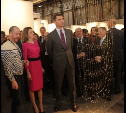 Don Felipe y Doña Letizia atienden a las explicaciones de uno de los artistas