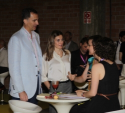 Sus Altezas Reales conversan con dos participantes de una sesión'networking'