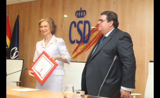 Doña Sofía muestra el el diploma acreditativo del'Pedalón solidario' entregado por el director general de Cofidis Hispania