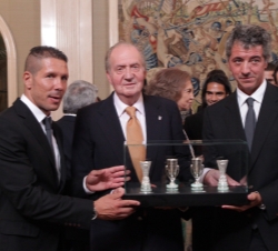 Don Juan Carlos acompañado por el consejero delegado del Club, Miguel Ángel Gil Marín, y el entrenador de la primera plantilla, Diego Pablo Simeone, c