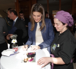 Doña Letizia dedica una fotografía a una joven colaboradora de la organización del encuentro