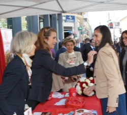 La Infanta coloca el distintivo de colabaroción con Caritas a una donante