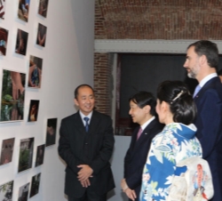 El Príncipe de Asturias y el Príncipe Heredero del Japón reciben explicaciones sobre algunas fotografías de la muestra