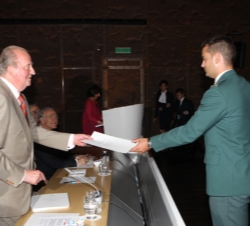 Don Juan Carlos entrega el diploma a un oficial de la Guardia Civil seleccionado para recibir una de las becas