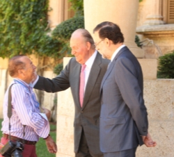 Don Juan Carlos acompañado por Mariano Rajoy, saluda al fotógrafo Juan Chávez que próximamente se jubila