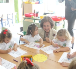 Su Majestad la Reina observa como pintan un grupo de niñas