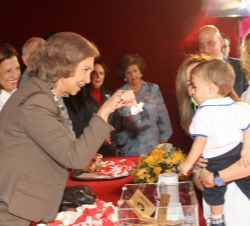 La Reina coloca el distintivo a un niño