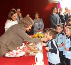 Doña Sofía coloca el distintivo a unos niños
