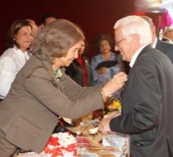 La Reina coloca el distintivo al padre Ángel