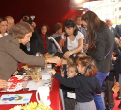Doña Sofía coloca el distintivo a unos niños