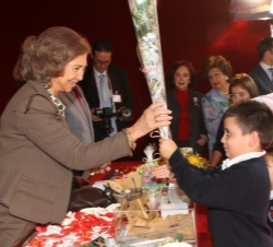 Unos niños obsequian con unas flores a Doña Sofía