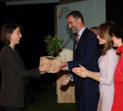 Don Felipe hace entrega del galardón a una de las premiadas