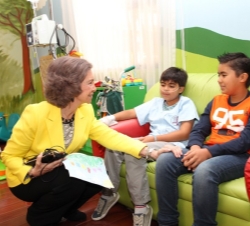 La Reina conversa con unos niños durante su visita al Sanatorio Nuestra Señora del Pilar.