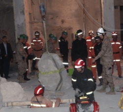 El Príncipe observa el desarrollo de las tareas de rescate tras el derrumbe de un edificio.