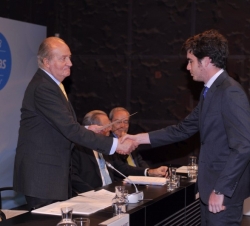 Su Majestad el Rey entrega el diploma a uno de los becarios.