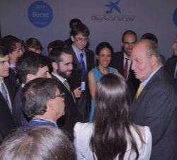 Don Juan Carlos conversa con los becarios al finalizar el acto.
