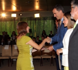 Don Felipe entrega el diploma a una de las becadas.