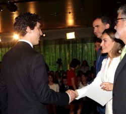 La Reina entrega el diploma a uno de los becados.