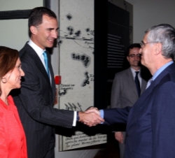 Don Felipe recibe el saludo del comisario de la exposición, Juan Miguel Hernández, en presencia de la directora de la Biblioteca Nacional, Ana Santos.