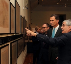 El Rey atiende a las explicaciones del comisario de la exposición.
