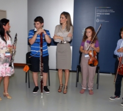 La Reina atiende a las explicaciones de una de las profesoras durante su recorrido por el conservatorio.