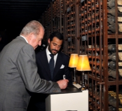 El Rey Don Juan Carlos firma en una pizarra, donde se encuentran los vinos de la añada 1938