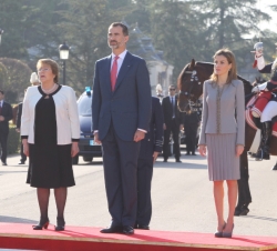 Sus Majestades los Reyes, acompañados de la Presidenta de la República de Chile, Michelle Bachelet, en el podio durante los honores militares