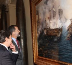 Su Majestad el Rey junto a Augusto Ferrer-Dalmau, observan el cuadro "El último combate del Glorioso"