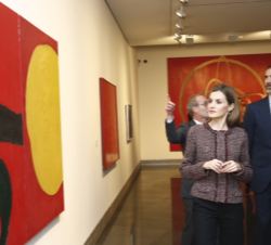 Sus Majestades los Reyes contemplan una de las obras durante la visita