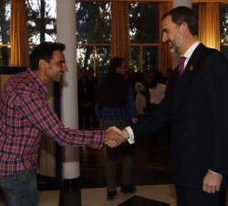Su Majestad el Rey saluda a uno de los cooperantes presentes en el encuentro con miembros de la colectividad española