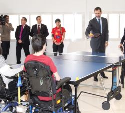 Sus Majestades los Reyes juegan al tenis de mesa con unos usuarios del centro en sillas de ruedas 