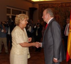 Don Juan Carlos es saludado durante la recepción que tuvo lugar en la residencia de la Embajada de España por una de las representantes de la colectiv