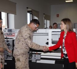 Su Majestad la Reina es saludada por un alumno durante su recorrido por el taller 