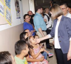 Su Majestad la Reina saluda a unos niños en la Unidad Comunitaria de Salud Familiar Especializada "Monseñor Oscar Arnulfo Romero"