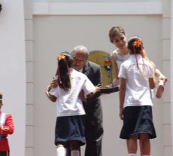 La Reina recibe un obsequio de manos de unas niñas.