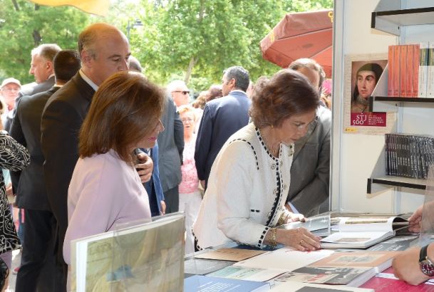 Su Majestad la Reina Doña Sofía hojea un libro durante la inauguración de la Feria del Libro de Madrid