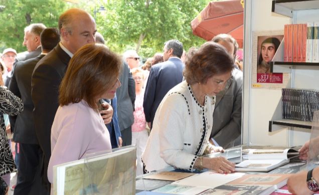 Su Majestad la Reina Doña Sofía hojea un libro durante la inauguración de la Feria del Libro de Madrid