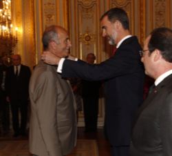 Su Majestad el Rey junto al Presidente Hollande impone la condecoración en reconocimiento a su labor con motivo de la tragedia aérea de Germanwings