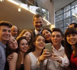 Varios asistentes al acto se fotografían con Su Majestad el Rey