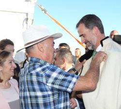 Don Edelfio Alonso, uno de los fundadores de "Los Sabandeños", coloca la capa característica a Don Felipe
